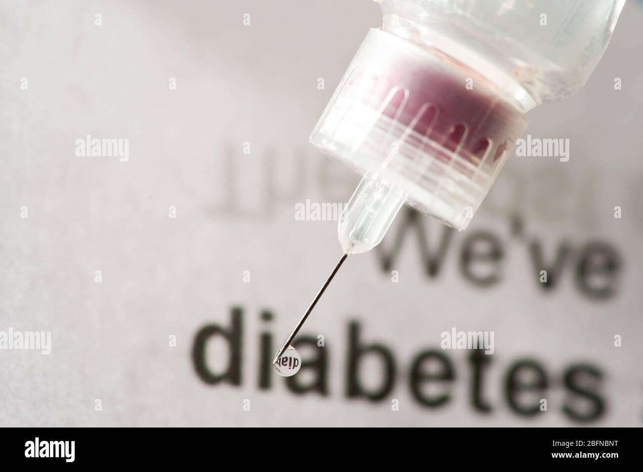 l'insuline s'écoulant de la nwwdle avec le mot diabète sur la paperasse en arrière-plan extrême gros plan Banque D'Images