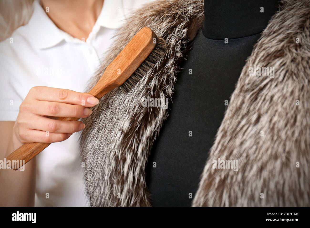 Concept commercial de nettoyage à sec. Femme travaillant avec un manteau et  une brosse à fourrure Photo Stock - Alamy