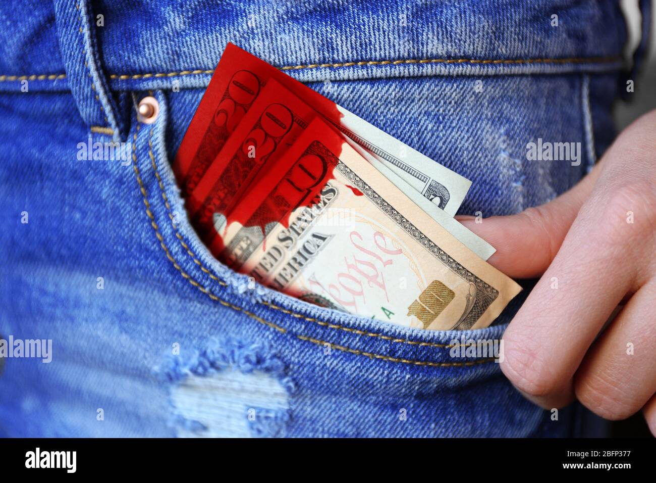 Billets en dollars avec tache de sang dans la poche de jeans closeup Photo  Stock - Alamy