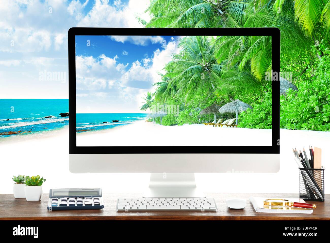 Image conceptuelle d'un espace de travail et d'un ordinateur de bureau avec des côtes et des arbres exotiques dans le complexe Banque D'Images