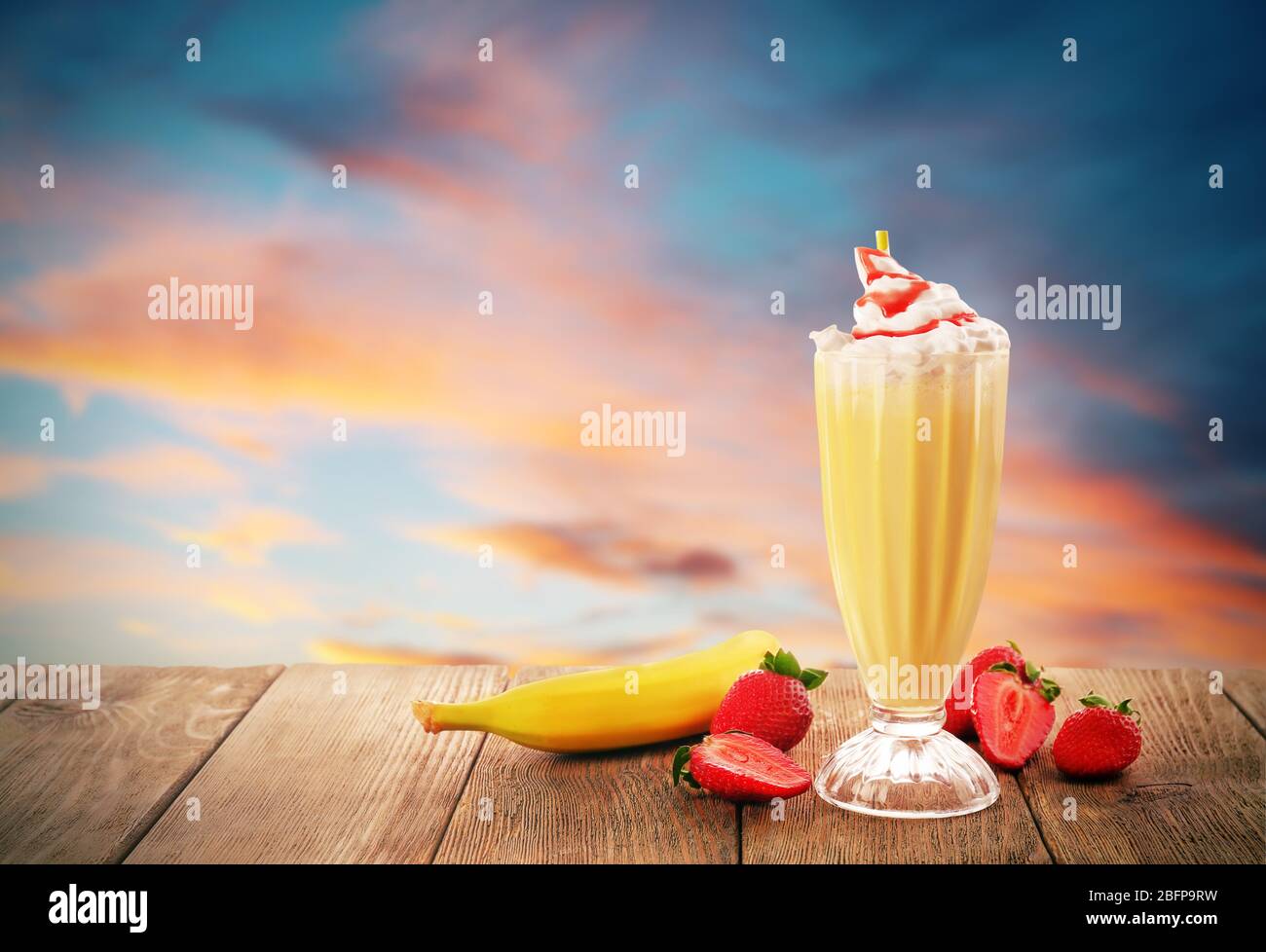 Délicieux milk-shake avec des fruits sur un magnifique fond de coucher de  soleil Photo Stock - Alamy