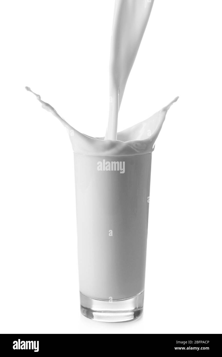 Verser du lait dans le verre sur fond blanc Banque D'Images