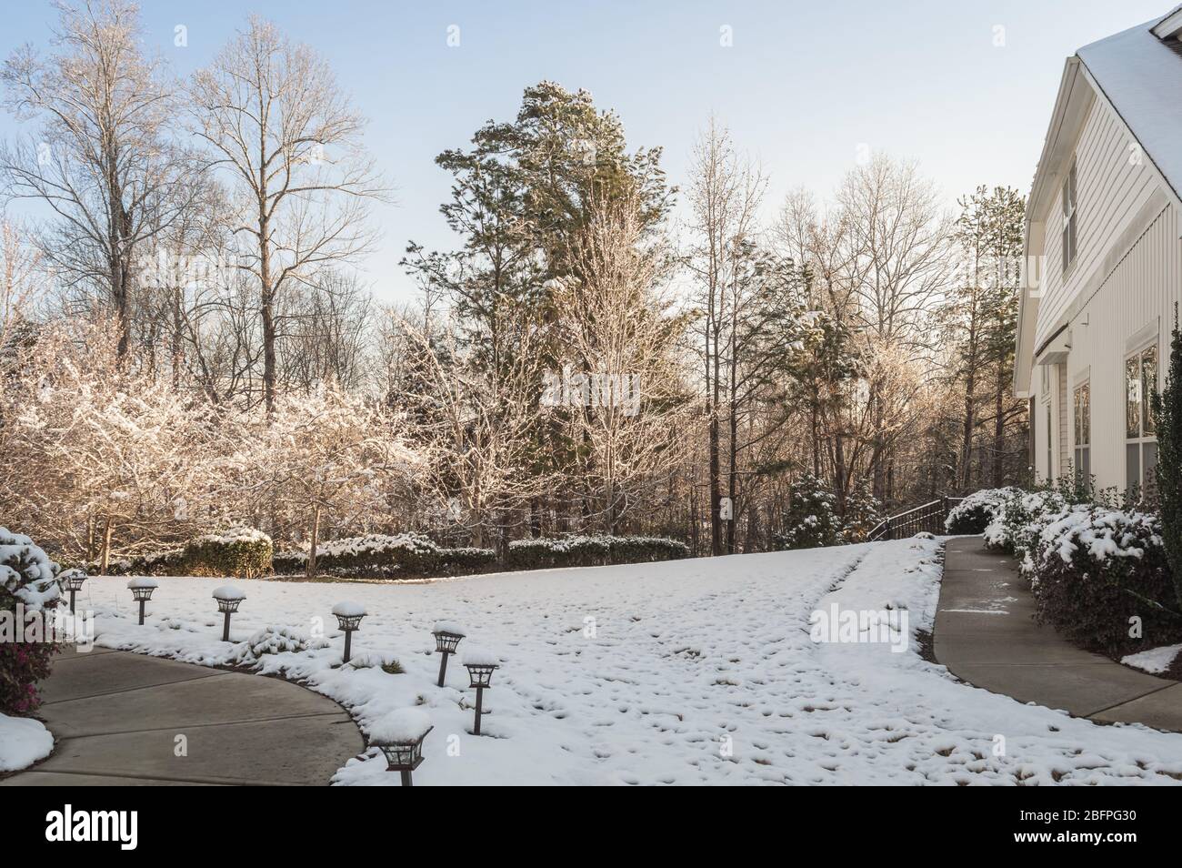 Neige couvrant la pelouse par une maison le matin d'hiver Banque D'Images
