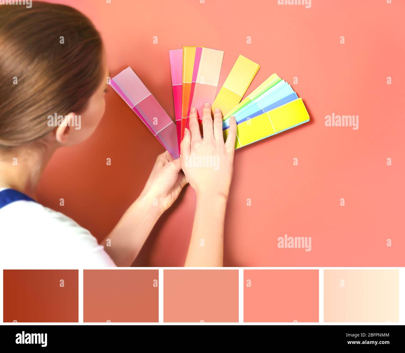 Palette de couleur saumon et jeune décorateur sélectionnant le ton du mur Banque D'Images