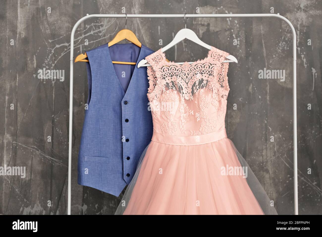 Robe de mariée de couleur saumon et gilet de robe pendante sur le rack au dressing Banque D'Images