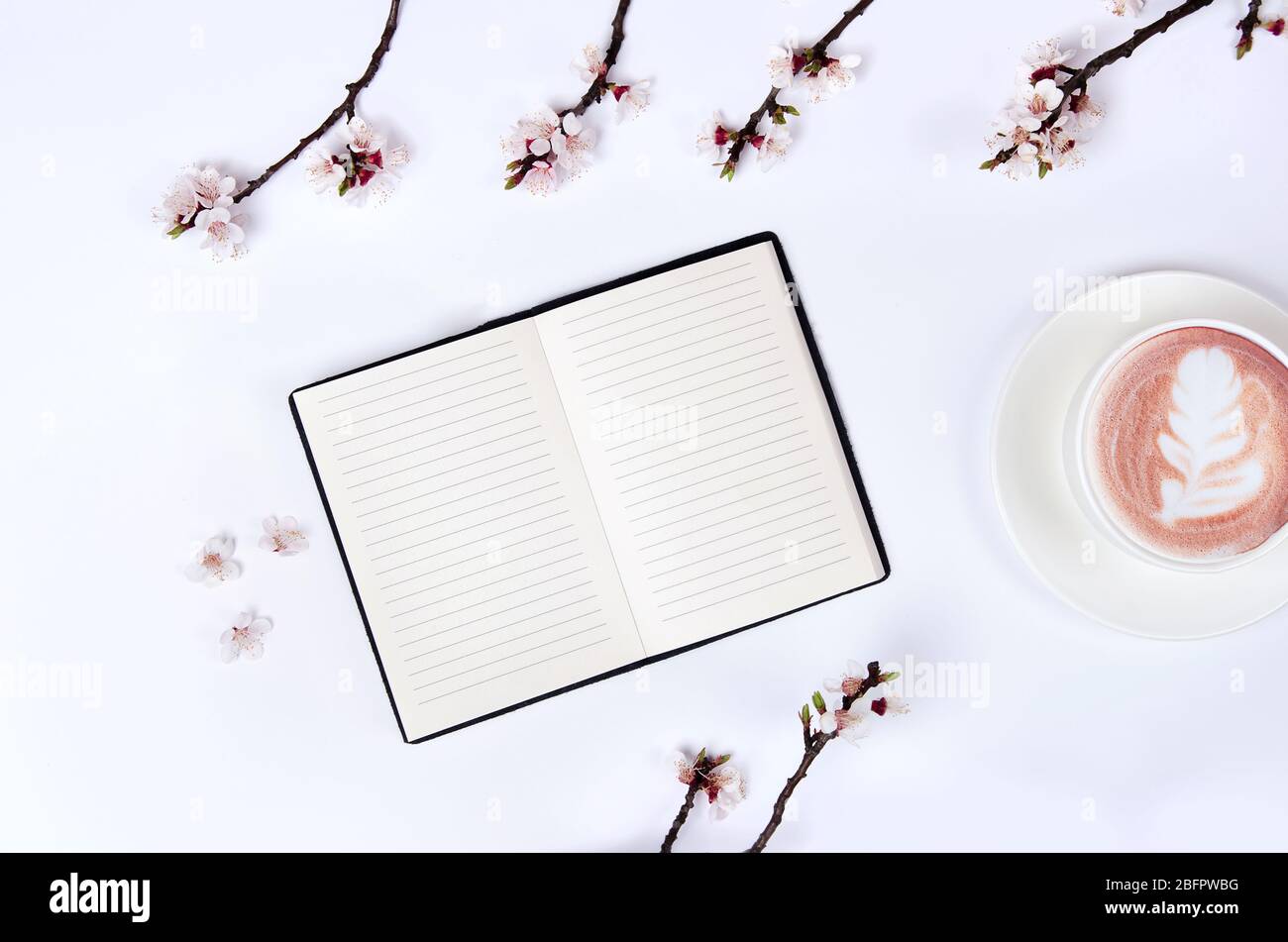 Liste de souhaits pour les plans futurs. composition de plat avec fleurs, verres et bloc-notes et café avec l'art latte Banque D'Images
