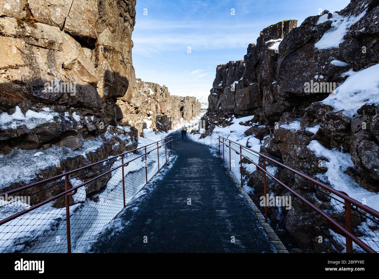 Chemin à travers la ligne de faille Almannagja dans la crête de l'Atlantique milieu dans le parc national de Thingvellir (Þingvellir) dans le sud-ouest de l'Islande dans la neige en hiver Banque D'Images