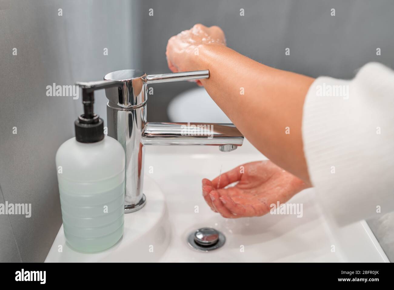 Lavage des mains hygiène étape fermeture robinet robinet avec bras au lieu de la main après séchage des mains pour la prévention de la contamination COVID-19. Précaution dans la salle de bains. Banque D'Images