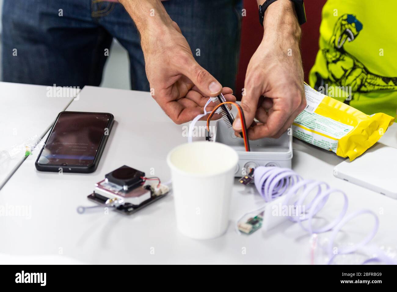 Montage du capteur de temps. Les petits composants électroniques sont assemblés et cousus à la table. Surveillance publique de la pollution atmosphérique. Banque D'Images
