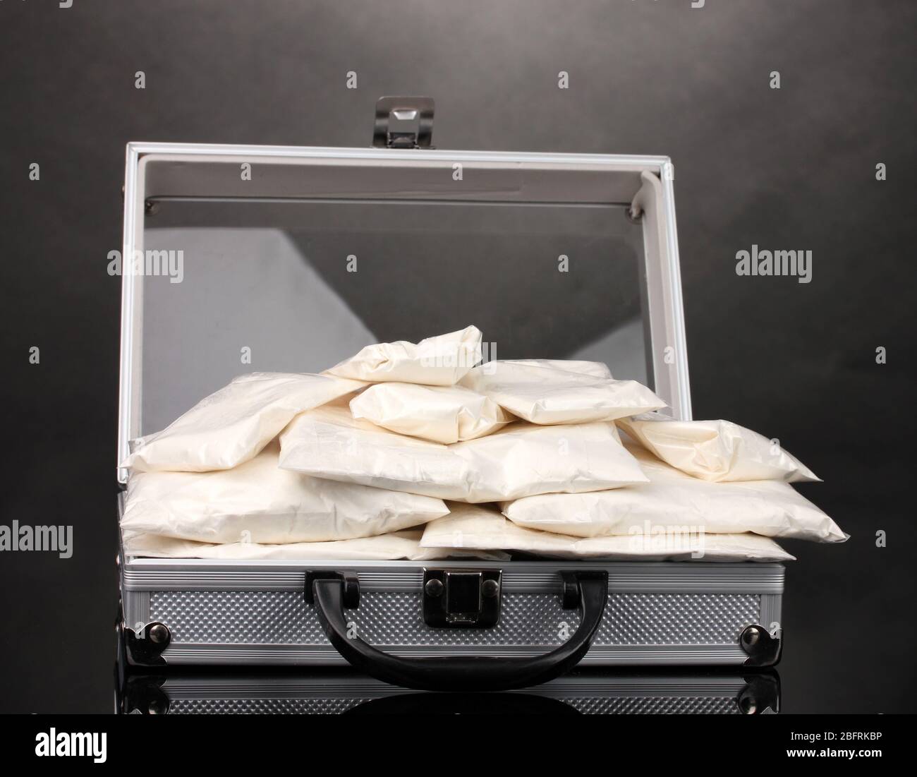 Cocaïne dans une valise sur fond gris Banque D'Images