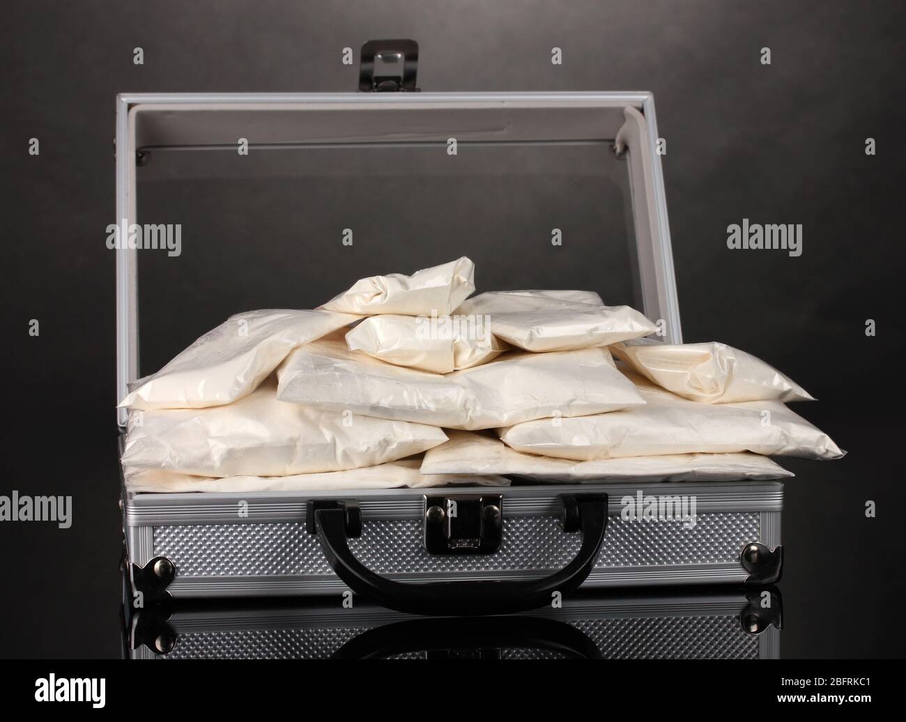 Cocaïne dans une valise sur fond gris Banque D'Images