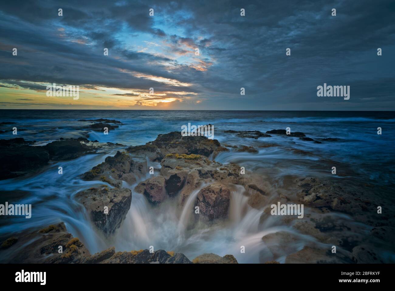 Les dernières couleurs du coucher du soleil illuminent le tube de lave connu sous le nom de Pele's well près de Wawaloli Beach sur la Grande île d'Hawaï. Banque D'Images