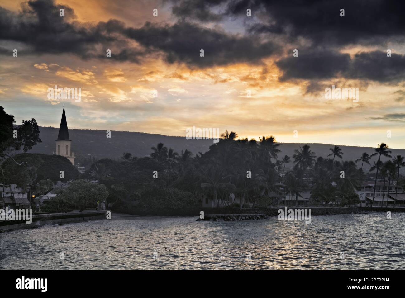 Daybreak au-dessus de la baie de Kailua et l'église historique de Mokuaikaua qui date de 1820 à Kailua-Kona sur la Grande île d'Hawaï. Banque D'Images
