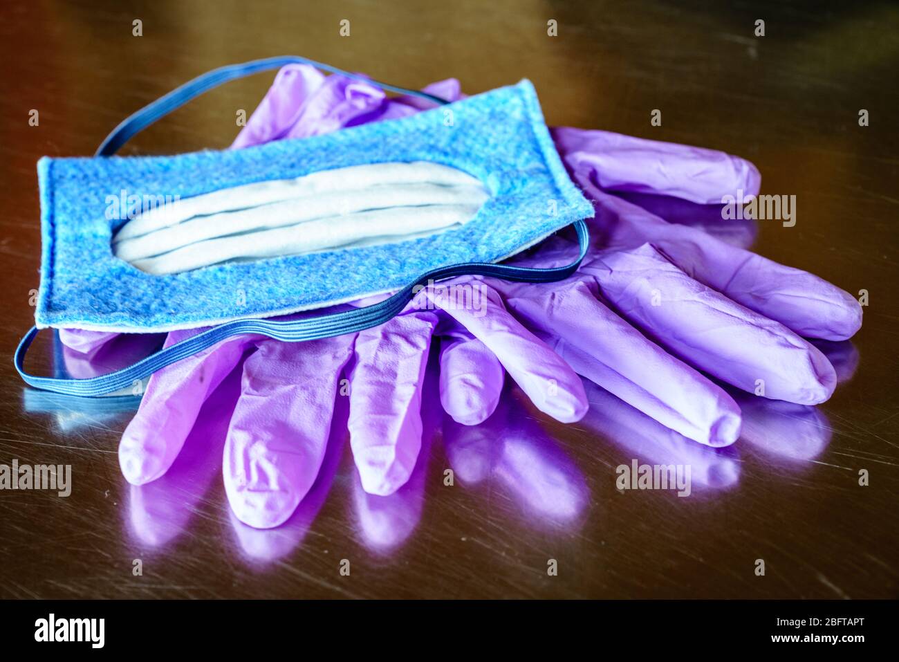 Image rapprochée du masque N-95 et des gants jetables en nitrile sur une surface en acier Banque D'Images