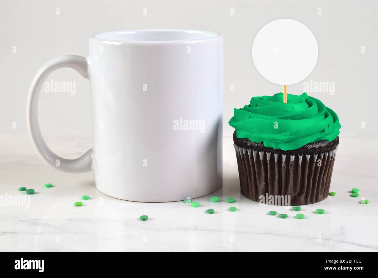 11 oz. Café froid à côté d'un cupcake vert de chocolat givré. Les saupoudrer de vert festif ornent cette maquette inspirée de Saint Patrick. Banque D'Images