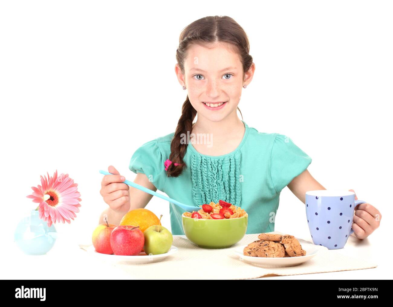 une petite belle fille a un petit déjeuner sur fond blanc Banque D'Images