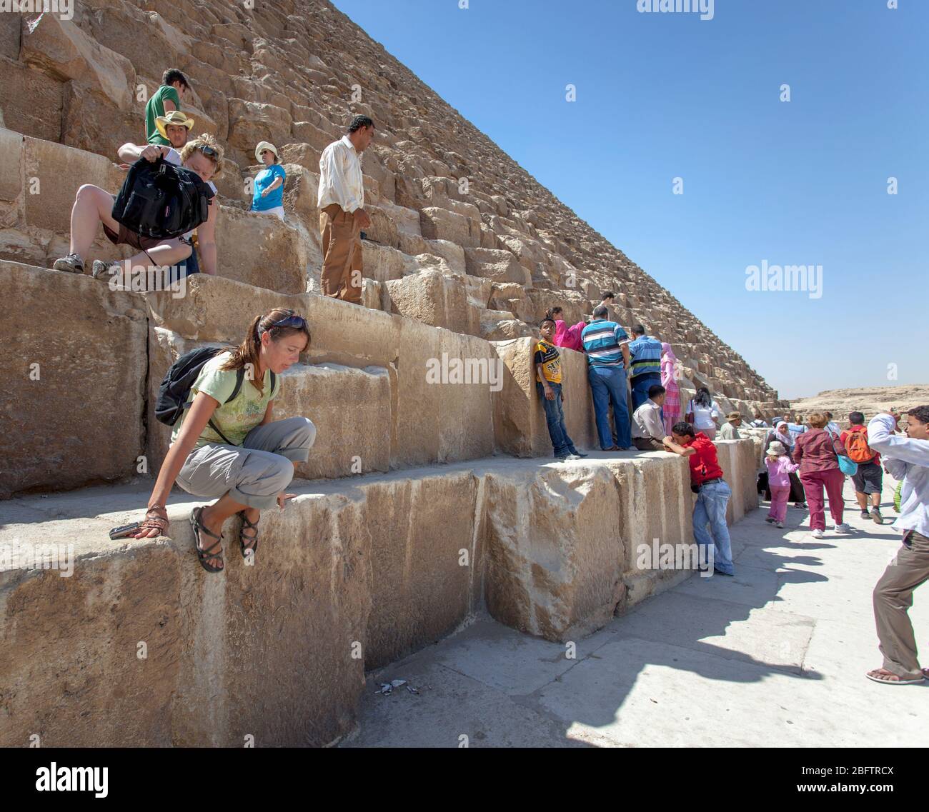 Les touristes grimpent sur la Grande Pyramide de Giza. Banque D'Images