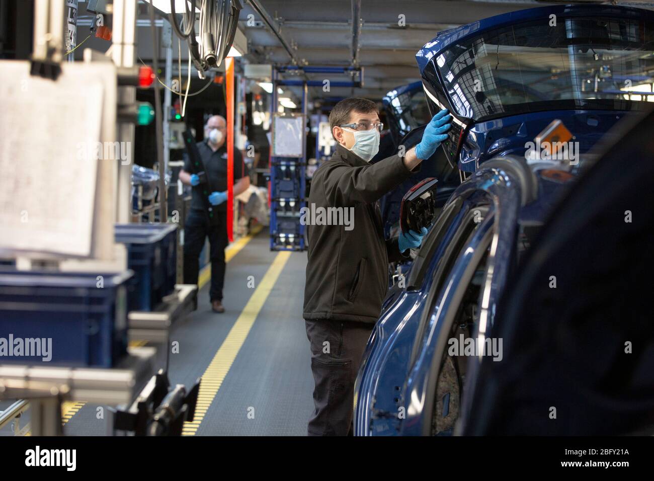 Les membres du personnel travaillant entre des postes de travail désignés de deux mètres de large sur une ligne d'assemblage de voiture à l'usine de véhicules Vauxhall pendant les essais de préparation et la refonte avant la réouverture après l'éclosion de COVID-19. Située à Ellesmere Port, à Wirral, l'usine a ouvert ses portes en 1962 et emploie actuellement environ 1100 travailleurs. Il a cessé sa production le 17 mars 2020 et ne reprendra ses travaux que sur les conseils du gouvernement britannique, qui impliquera des mesures physiques rigoureuses de distanciation sur l'ensemble du site. Banque D'Images