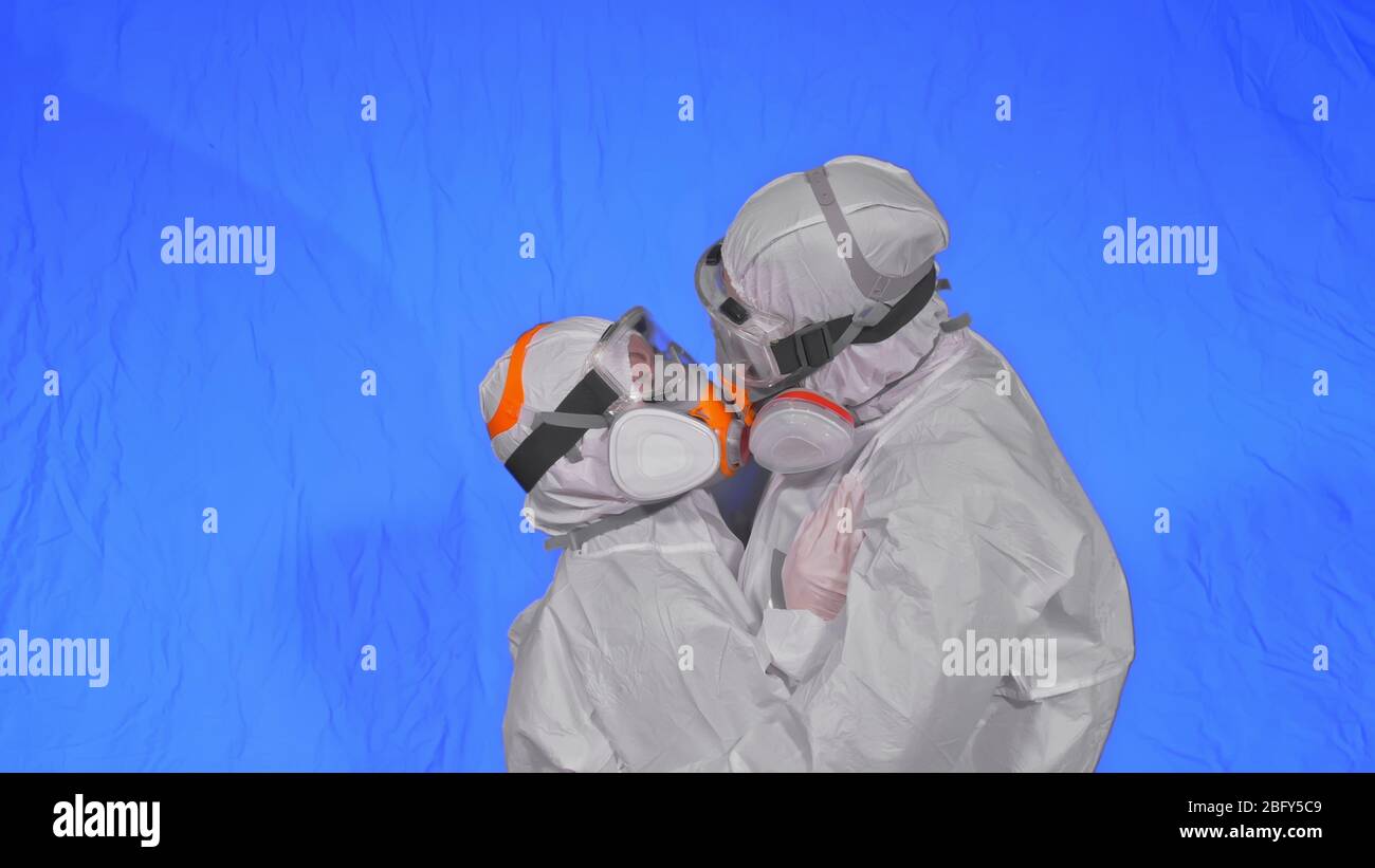Médecin homme et femme en costume de protection, protection au gaz masque de peinture pour spray médical. J'adore le baiser et le câlin de couple, un professionnel de la santé dans le respirateur Covid-19. Banque D'Images