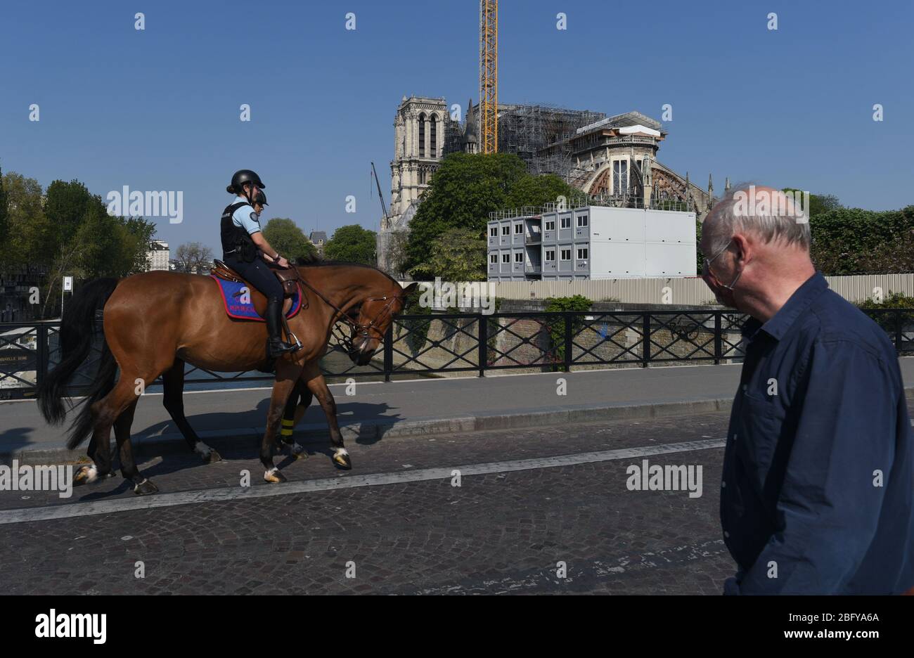 *** STRICTEMENT AUCUNE VENTE AUX MÉDIAS OU ÉDITEURS FRANÇAIS - DROITS RÉSERVÉS ***12 avril 2020 - Paris, France: Police française dans les rues de patrouille à cheval de Paris pendant le verrouillage, avec la cathédrale notre Dame en arrière-plan. Banque D'Images