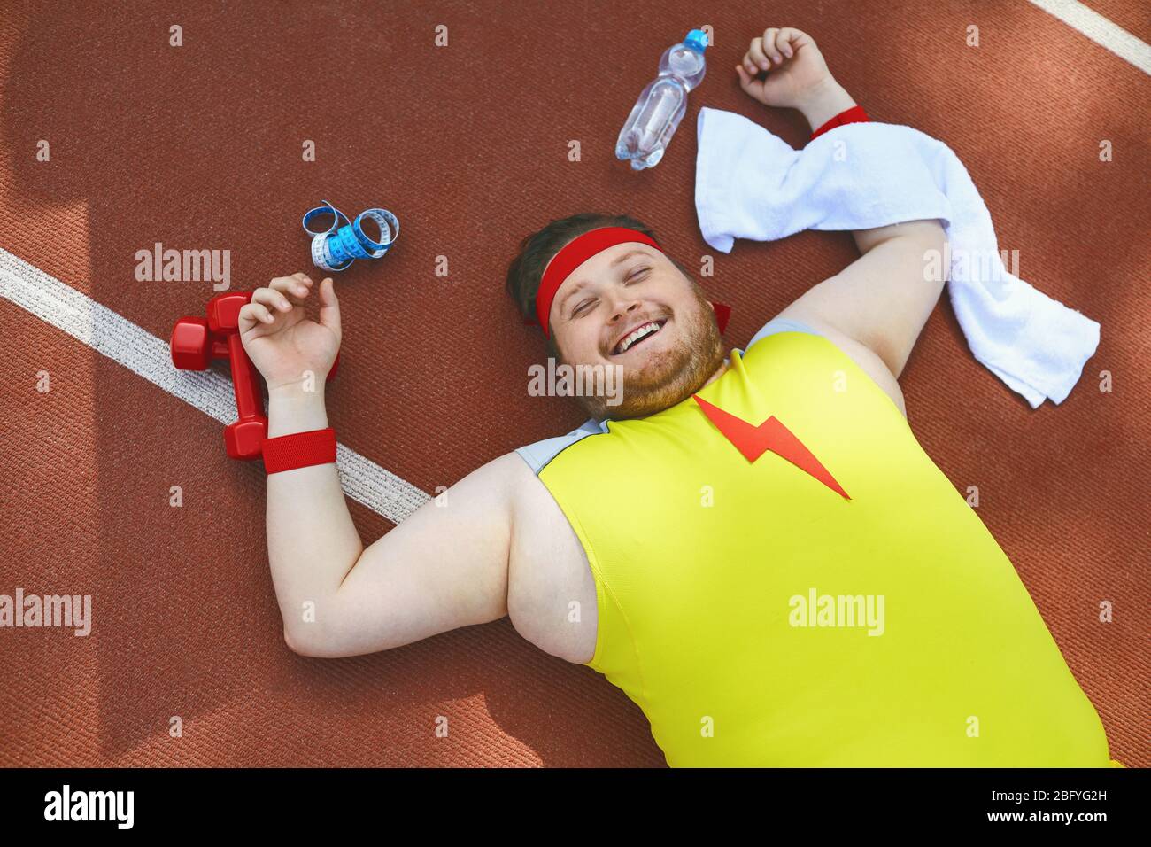 FAT paresseux dort fatigué se trouve sur la piste dans le stade. Banque D'Images