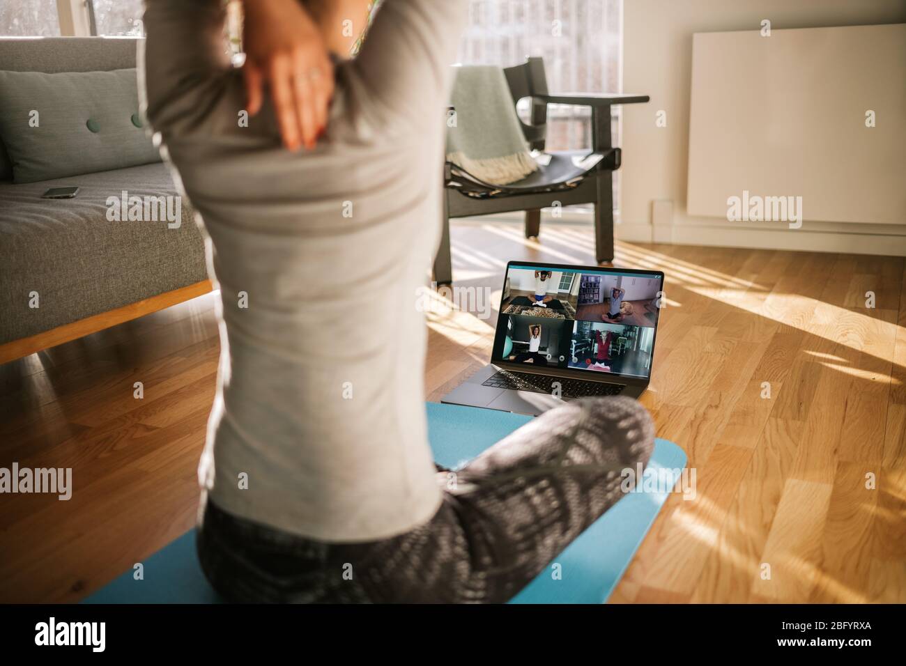 entraîneur de fitness enseignant le yoga en ligne à un groupe de personnes. Formateur de yoga démontrant des poses de yoga aux étudiants par vidéoconférence. Banque D'Images