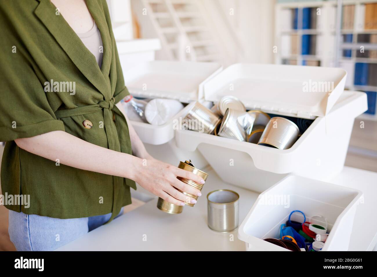 Gros plan sur une femme non reconnaissable mettant des bidons de métal jetés dans un conteneur en plastique tout en triant les déchets à la maison pour le recyclage, l'espace de copie Banque D'Images Gros plan sur une femme non reconnaissable mettant des bidons de métal jetés dans un conteneur en plastique tout en triant les déchets à la maison pour le recyclage, l'espace de copie Banque D'Images