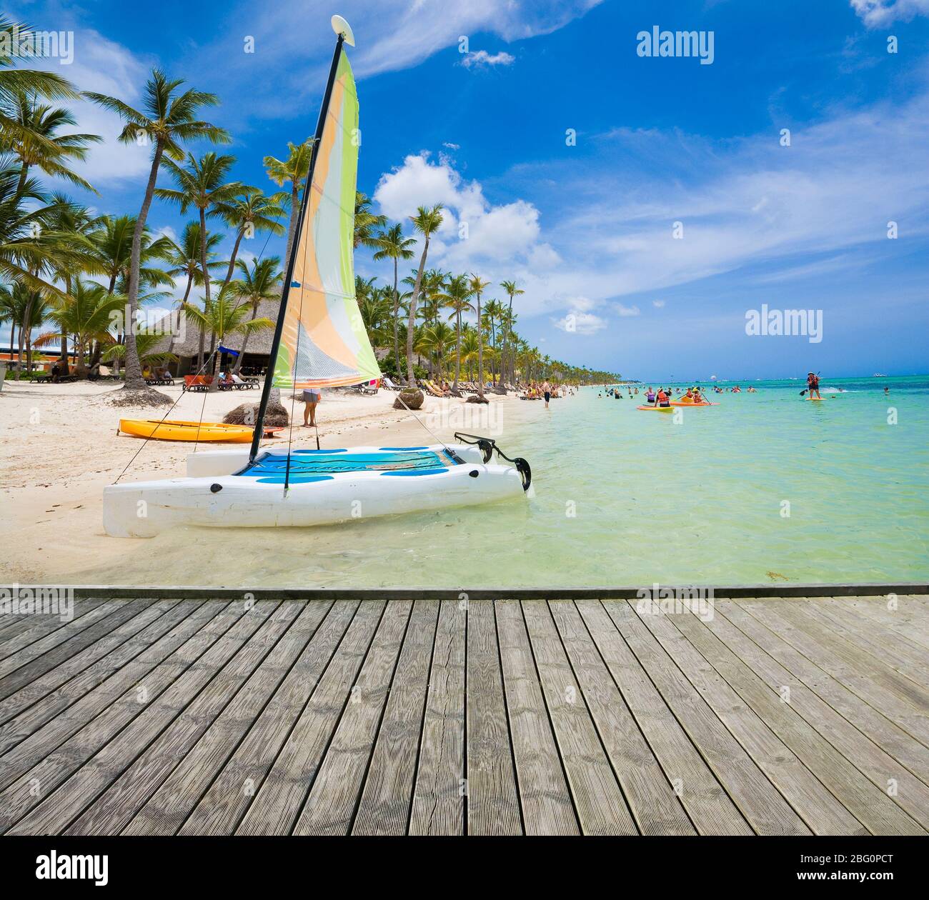 Plate-forme en bois vide à côté de la plage tropicale à Punta Cana, République dominicaine. Voilier amarré au bord de la mer de Sargasso en arrière-plan Banque D'Images