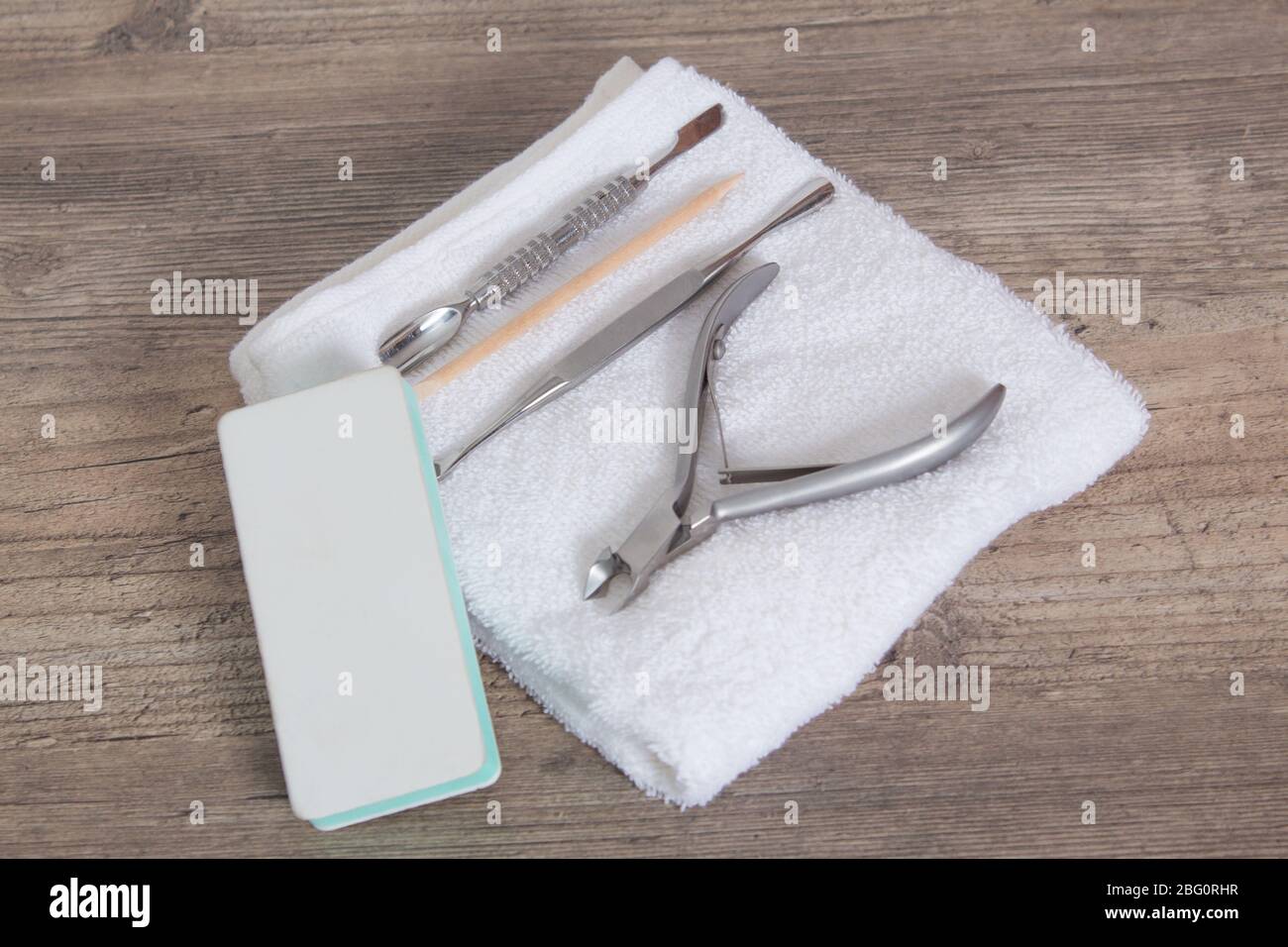 Un ensemble d'outils pour manucure sur une serviette blanche. Soin des ongles, procédure, salon de manucure. Brucelles, coupe-fils, poussoir, bâton orange pour arbres, ciseaux, lime à ongles Banque D'Images