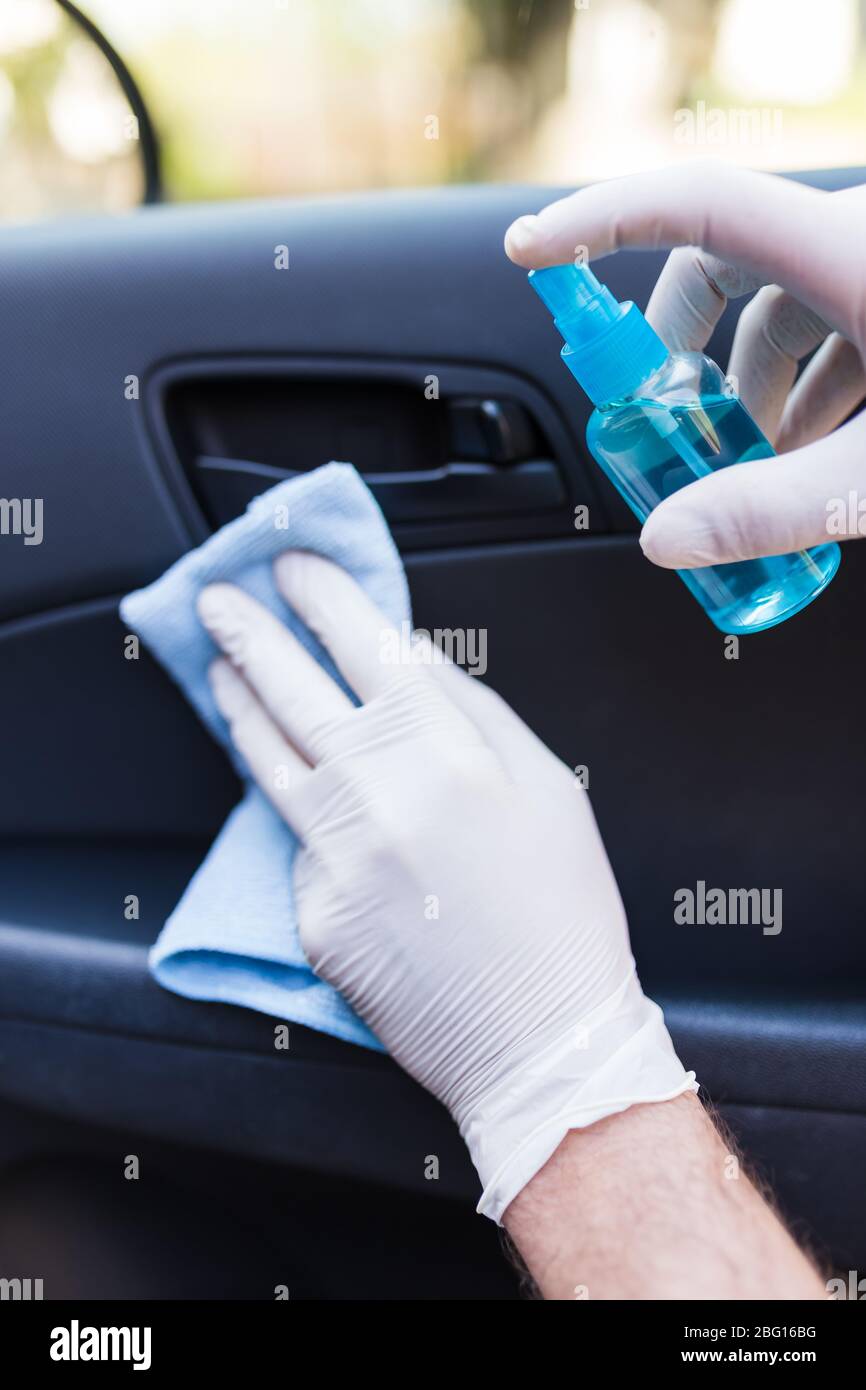 Main Avec Gant à L'aide D'une Lingette Humide Et D'un Spray Antibactérien  Pour Nettoyer L'intérieur De La Voiture