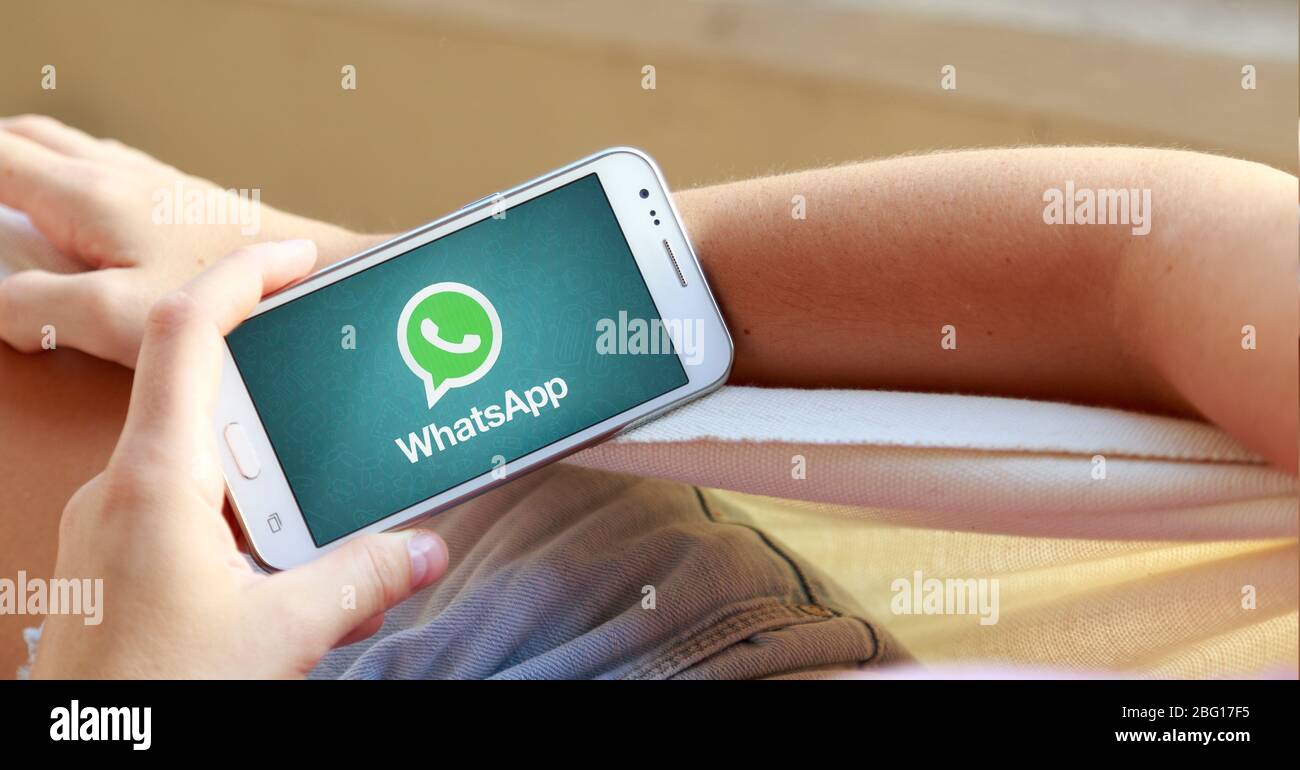 Femme dans un hamac avec un smartphone avec l'application whatsapp à l'écran. Banque D'Images