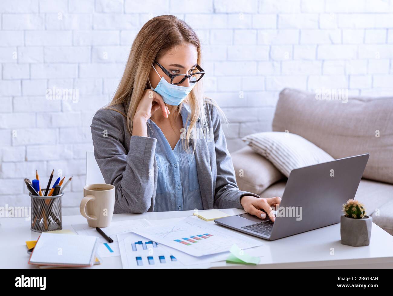 Femme en protection du visage sur le lieu de travail rester à la maison Banque D'Images