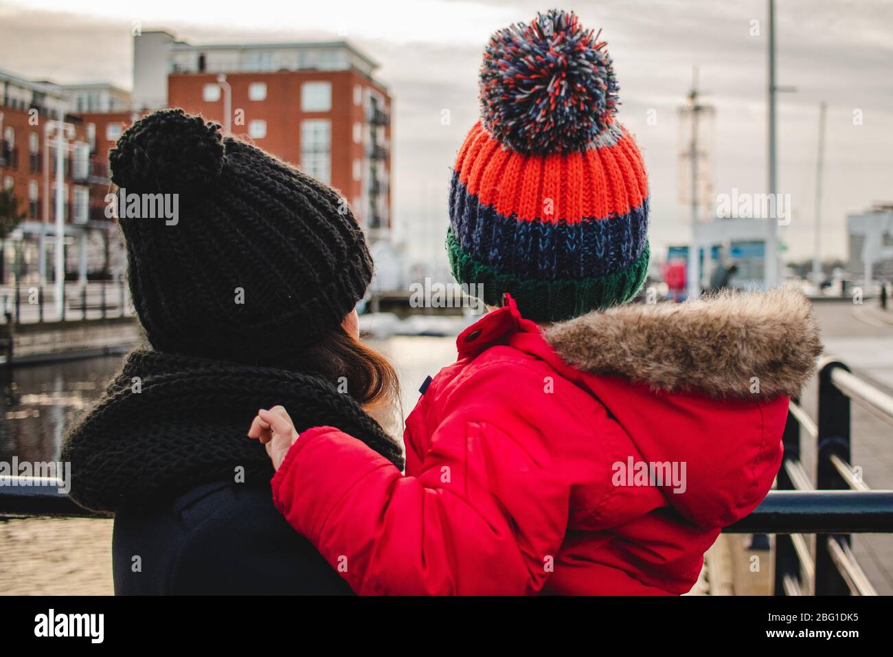 Une mère tenant son fils dans ses bras en regardant une vue, à la fois porter des vêtements d'hiver et un chapeau de bobble Banque D'Images
