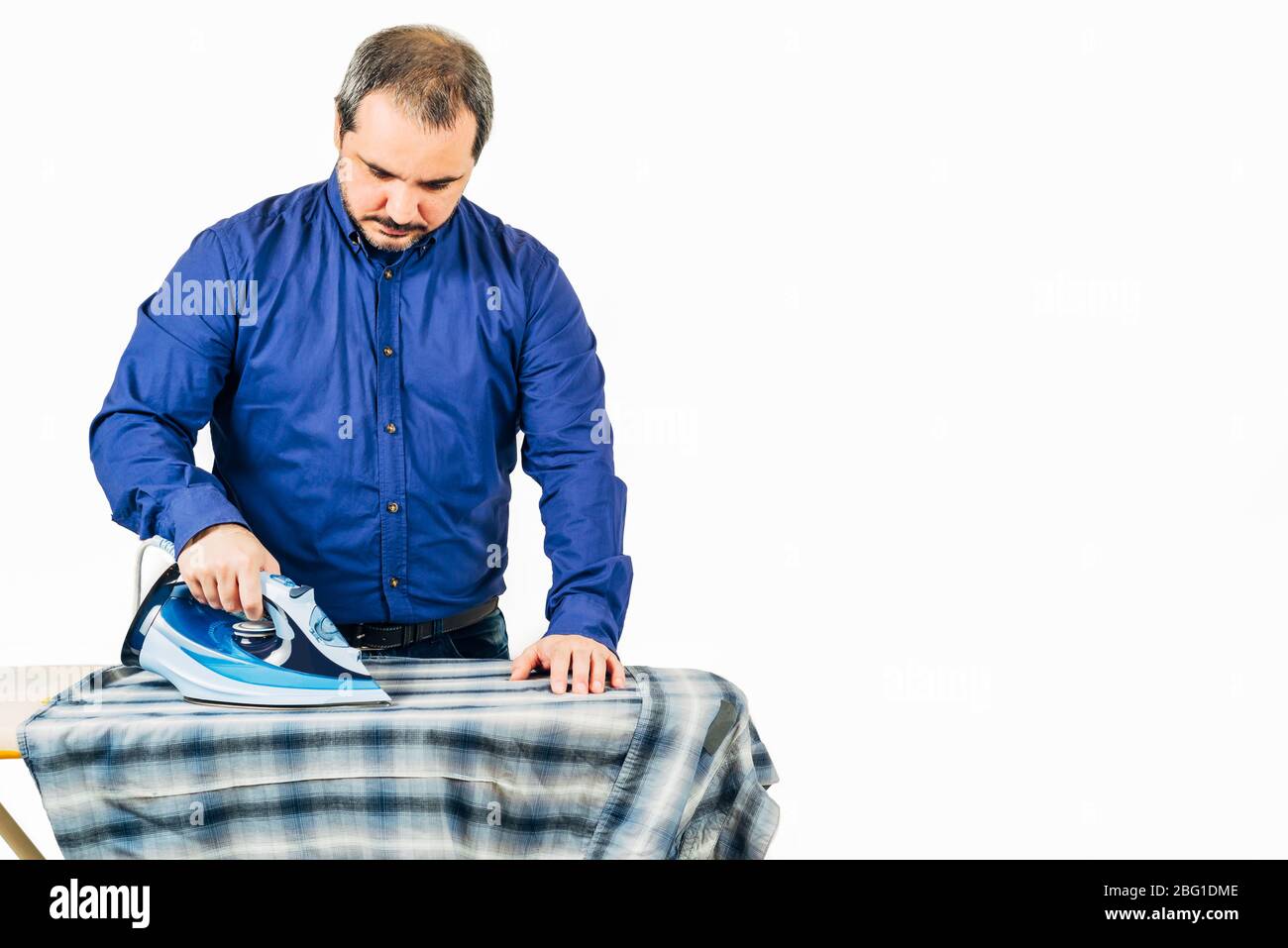homme repassage chemise bleue sur fond blanc avec espace pour le texte Banque D'Images