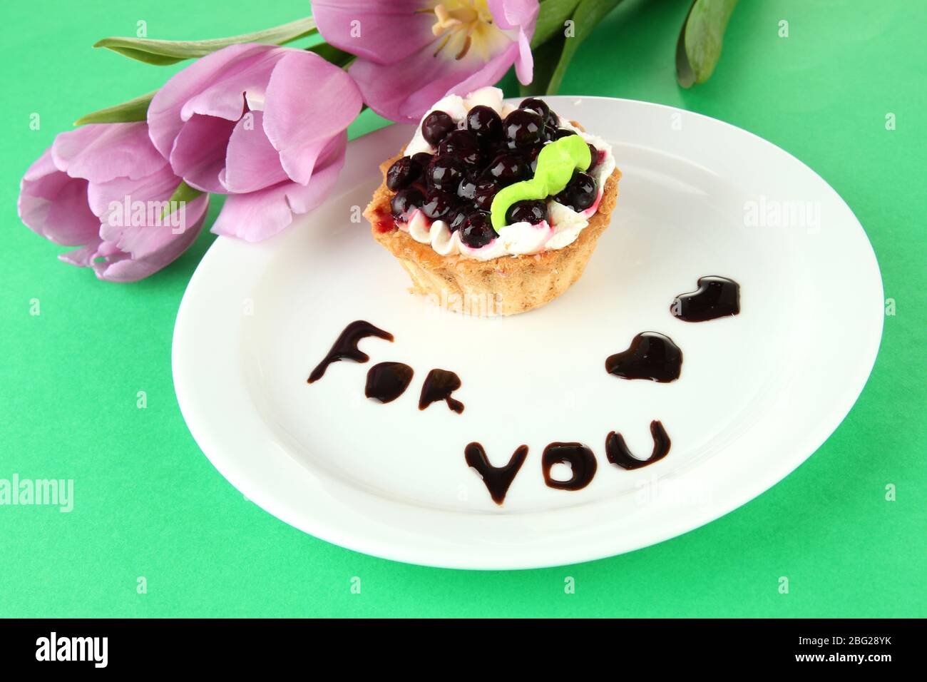 Gâteau sucré avec sauce au chocolat et au blackberry sur plaque, sur fond de couleur Banque D'Images