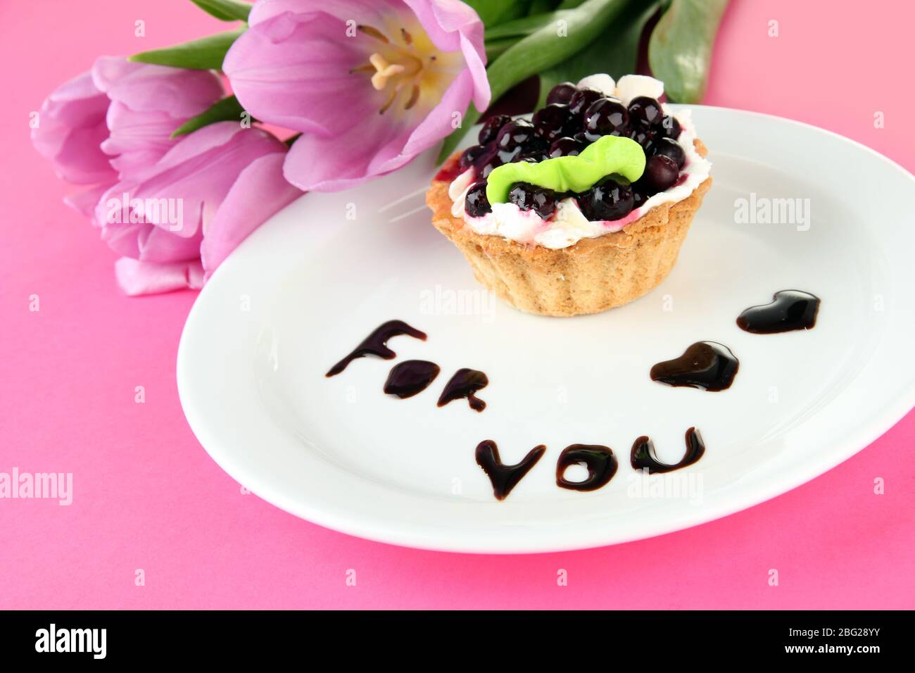 Gâteau sucré avec sauce au chocolat et au blackberry sur plaque, sur fond de couleur Banque D'Images