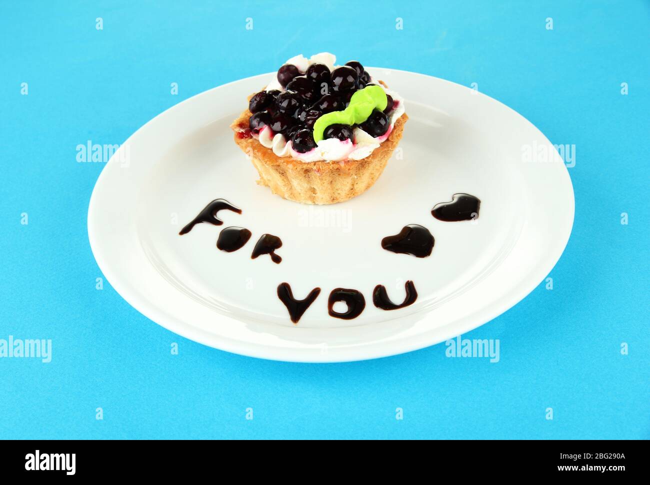 Gâteau sucré avec sauce au chocolat et au blackberry sur plaque, sur fond de couleur Banque D'Images