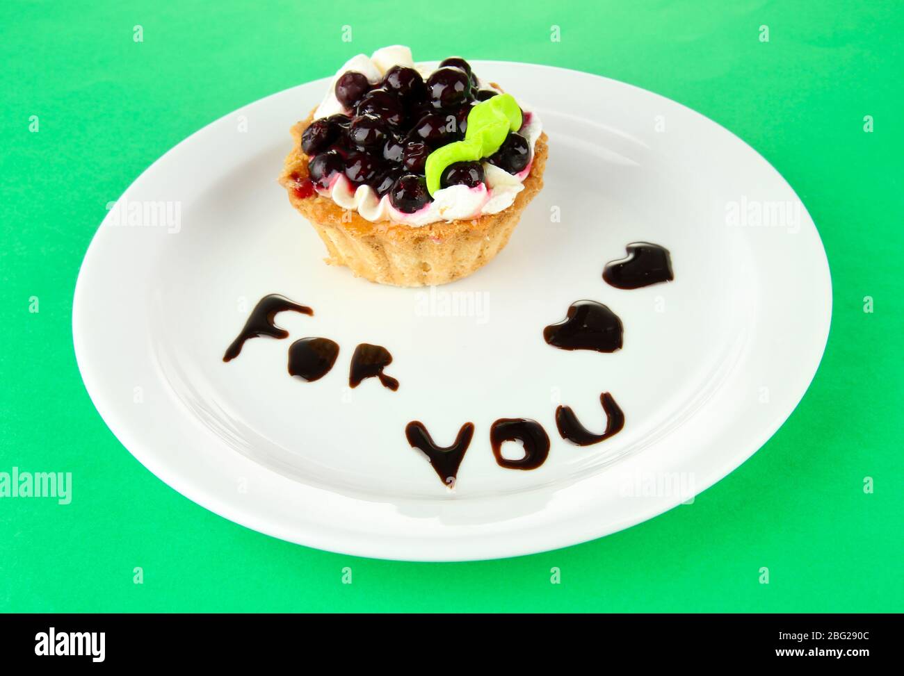 Gâteau sucré avec sauce au chocolat et au blackberry sur plaque, sur fond de couleur Banque D'Images