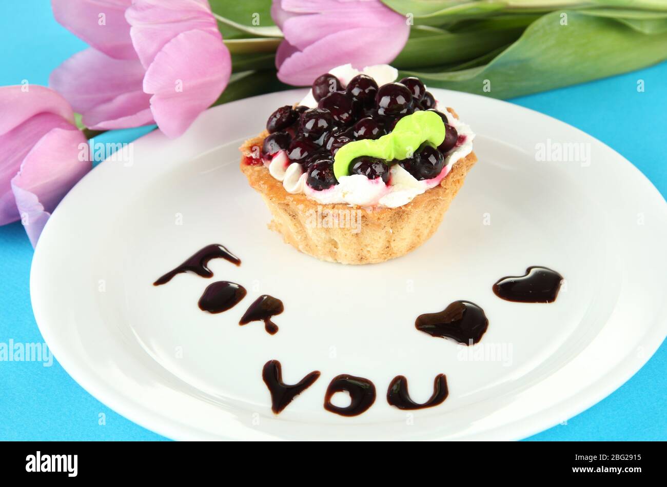 Gâteau sucré avec sauce au chocolat et au blackberry sur plaque, sur fond de couleur Banque D'Images