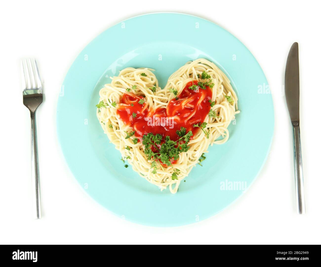 Spaghetti cuit soigneusement arrangé en forme de coeur et recouvert de sauce tomate, isolé sur blanc Banque D'Images