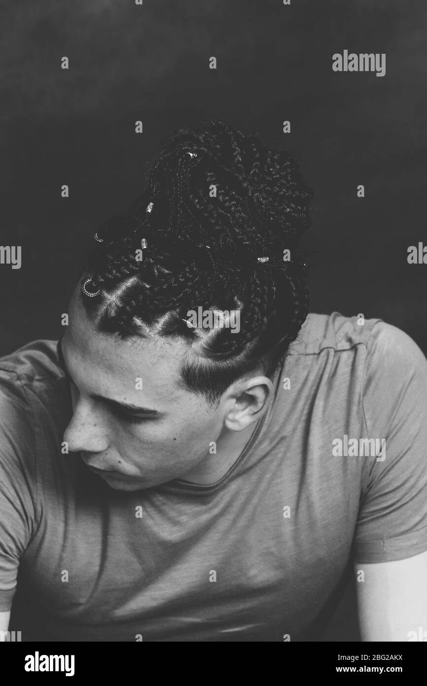 Modèle masculin élégant avec des tresses afro posé en studio sur un arrière-plan isolé. Style, tendances, mode concept. Banque D'Images Modèle masculin élégant avec des tresses afro posé en studio sur un arrière-plan isolé. Style, tendances, mode concept. Banque D'Images
