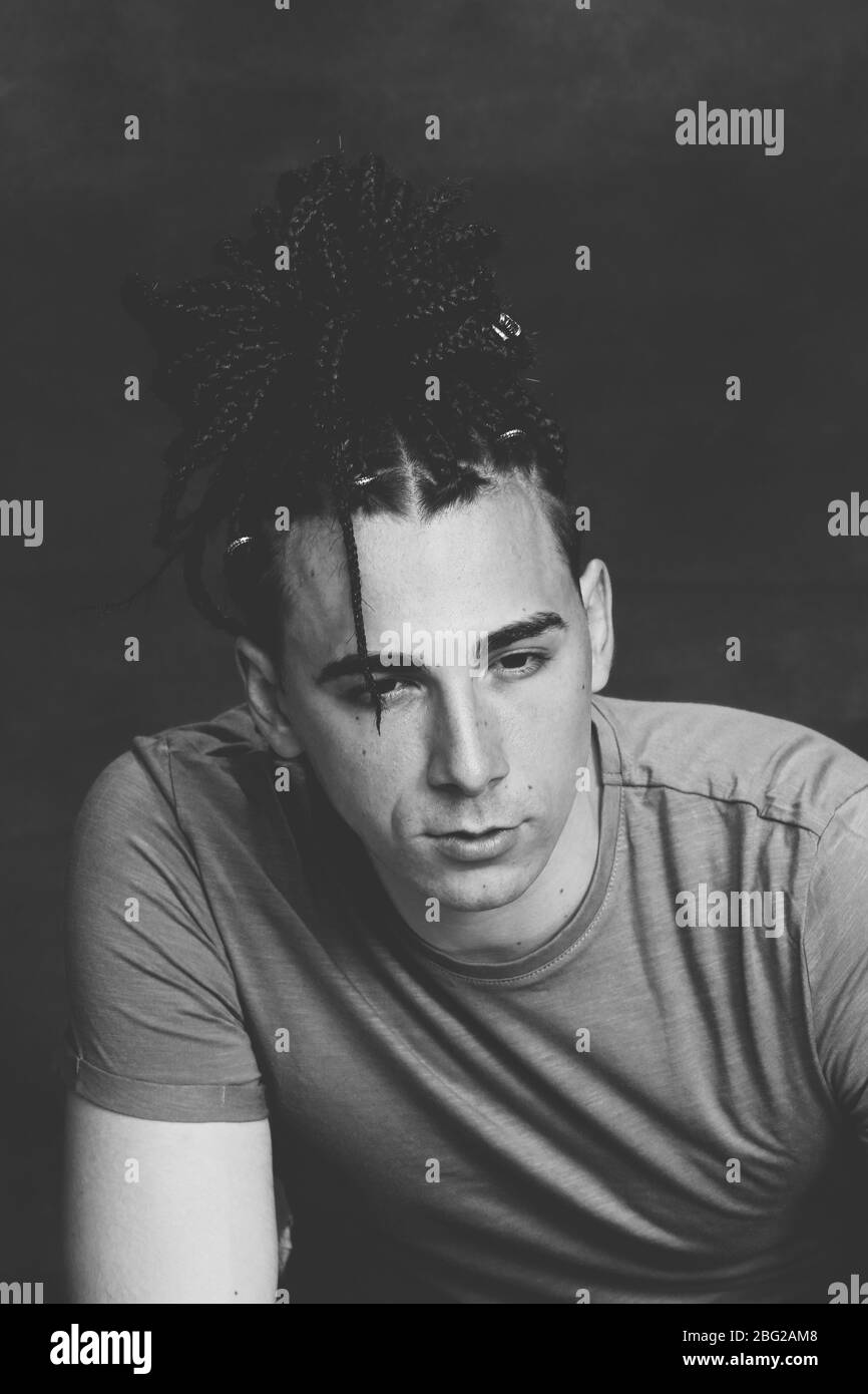 Modèle masculin élégant avec des tresses afro posé en studio sur un arrière-plan isolé. Style, tendances, mode concept. Banque D'Images Modèle masculin élégant avec des tresses afro posé en studio sur un arrière-plan isolé. Style, tendances, mode concept. Banque D'Images