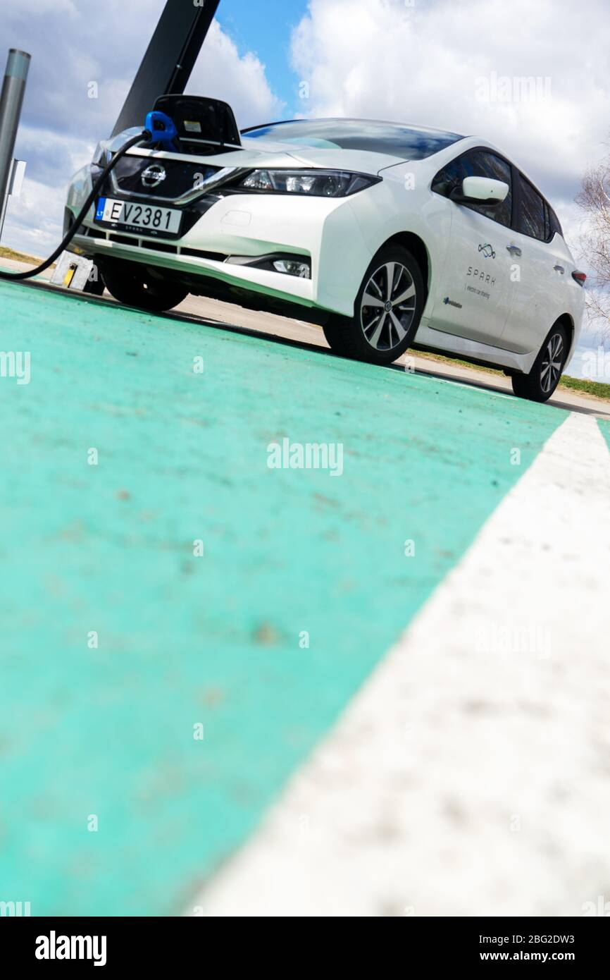 Point de charge de voiture électrique avec Nissan Leaf connecté. Station de parking et de recharge pour véhicules électriques. Banque D'Images