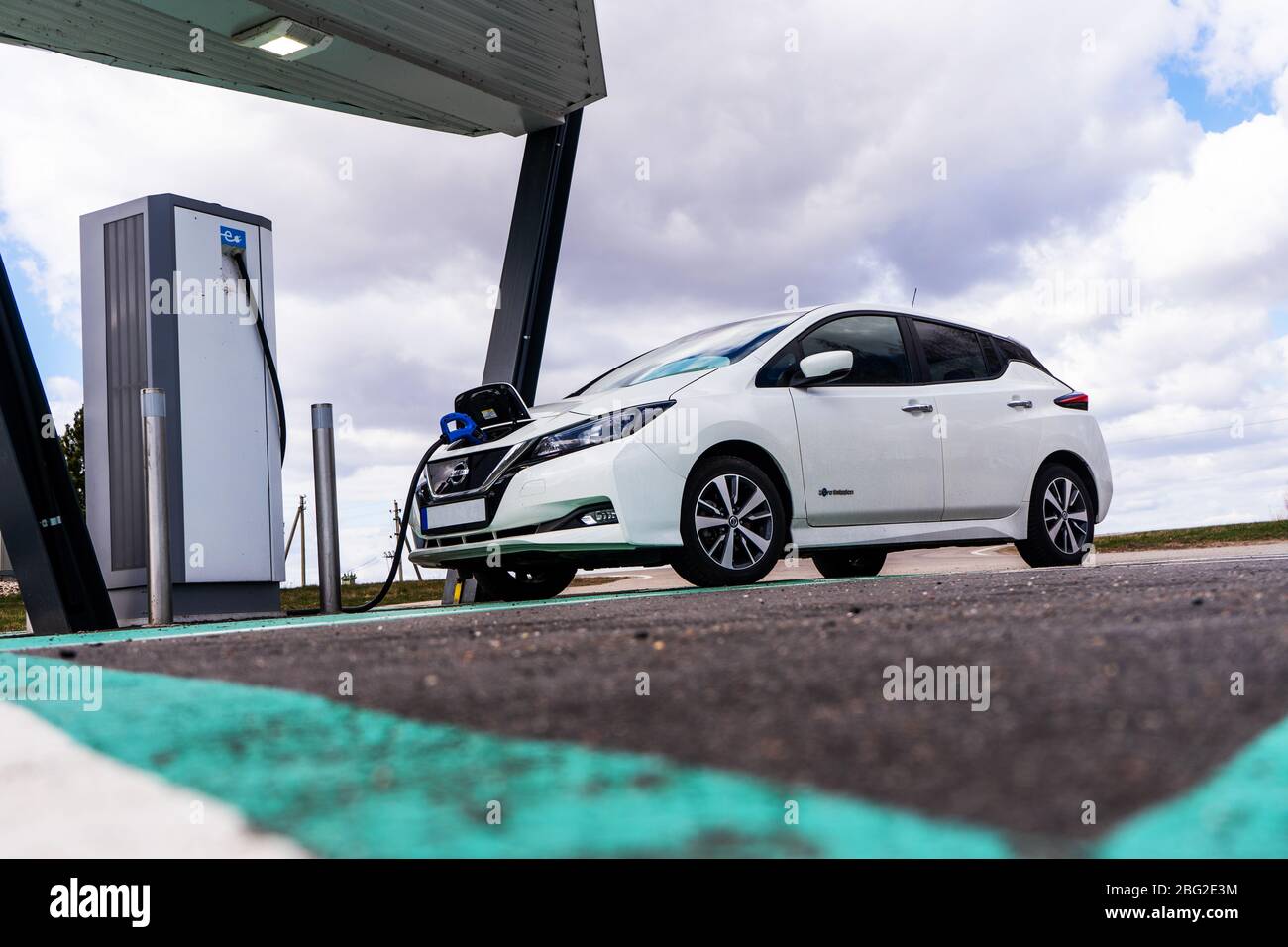 Point de charge de voiture électrique avec Nissan Leaf connecté. Station de parking et de recharge pour véhicules électriques. Banque D'Images