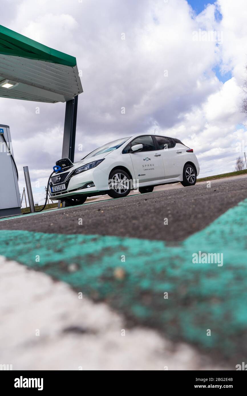 Point de charge de voiture électrique avec Nissan Leaf connecté. Station de parking et de recharge pour véhicules électriques. Banque D'Images