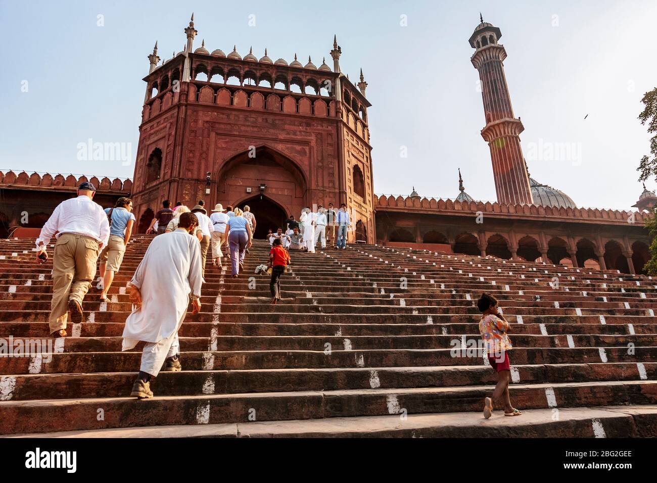 Les touristes montent sur les marches de l'entrée nord-ouest de la Mosquée de grès rouge de Jama Masjid à Delhi, en Inde Banque D'Images