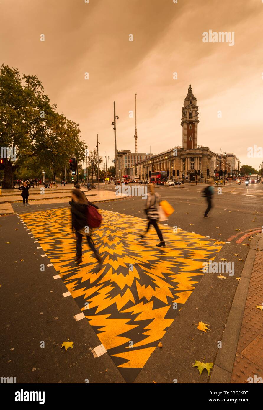 Les piétons traversent Coldport Lane avec l'hôtel de ville de Lambeth en arrière-plan, pendant l'ouragan Ophelia qui a tourné le ciel jaune/orange, Londres Banque D'Images