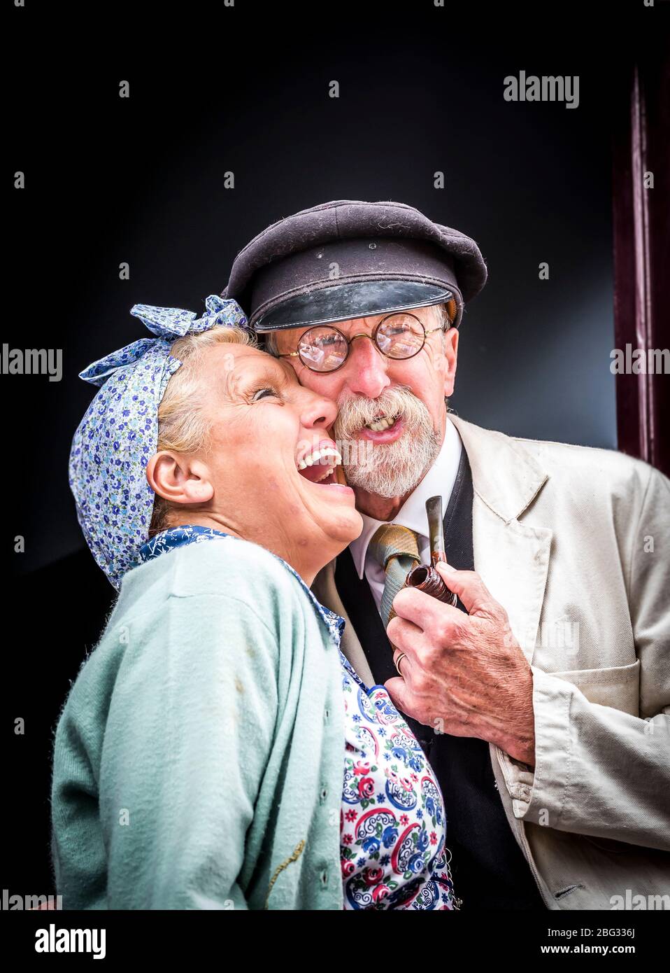 En 1940, un couple marié s'habille en riant ensemble dans le cadre d'une maison ancienne, le Black Country Living Museum 1940, deuxième Guerre mondiale, événement d'été britannique. Banque D'Images