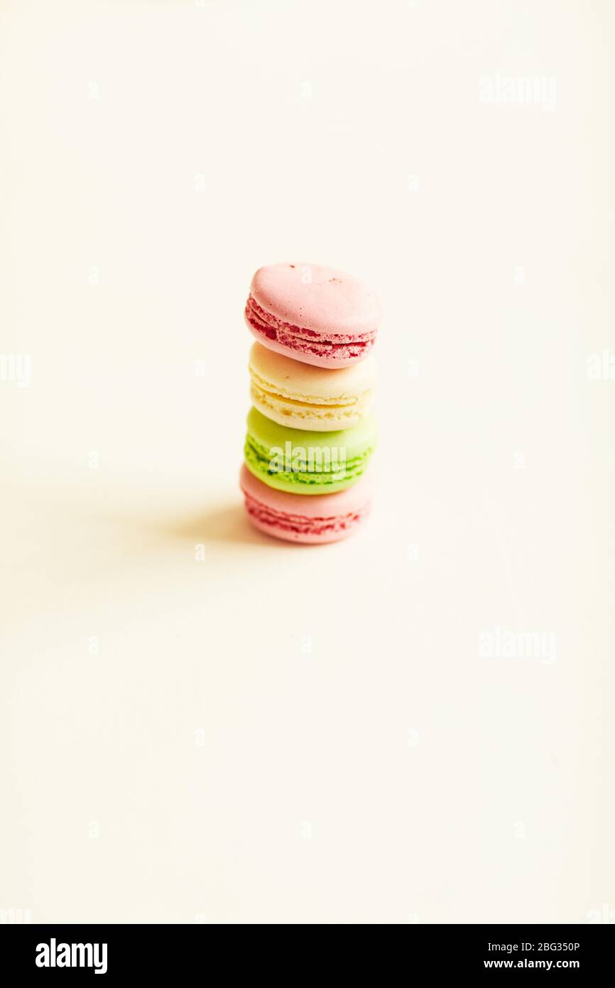 Composition minimale de macarons doux de couleur pastel empilés en rangée sur fond blanc en studio, espace de copie Banque D'Images