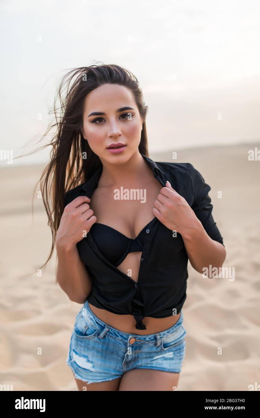 Jeune femme voyageur marchant sur des dunes de sable. Banque D'Images